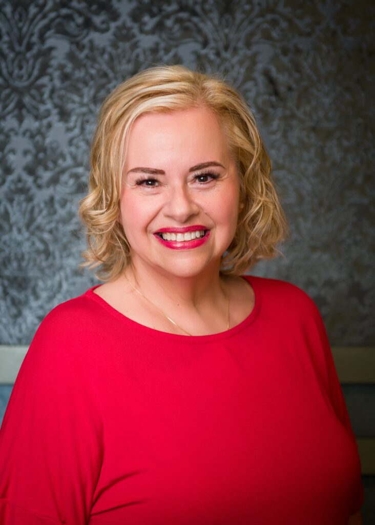 Marcia dressed in red, smiling